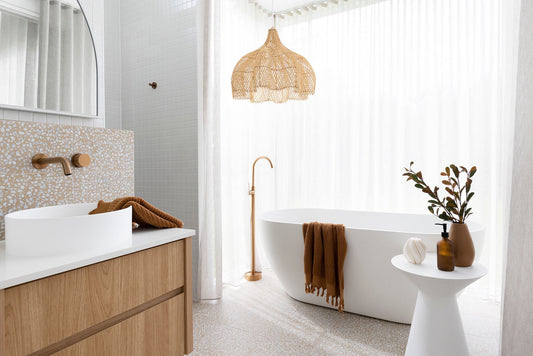 Whitehaven bathroom pendant lighting over a freestanding bath with brass tapware.