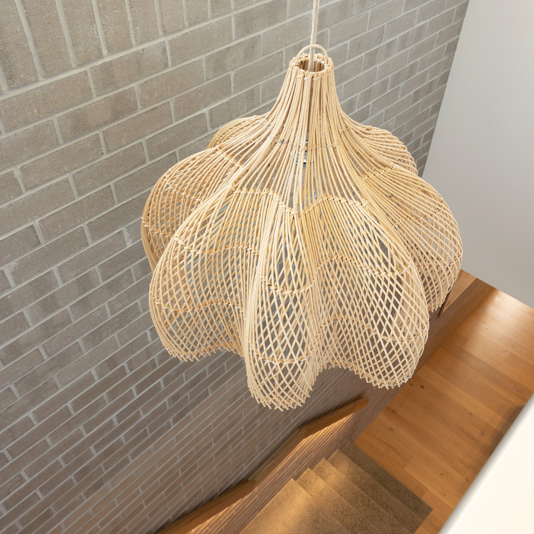 An Oversized Whitehaven rattan pendant lights sits over a stairwell
