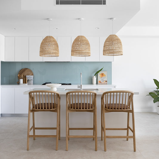 Three Elliston handmade pendant lights hang over a white island bench. The kitchen has a calming and practical light blue glass backsplash. Perfect for a modeern coastal Australian home.