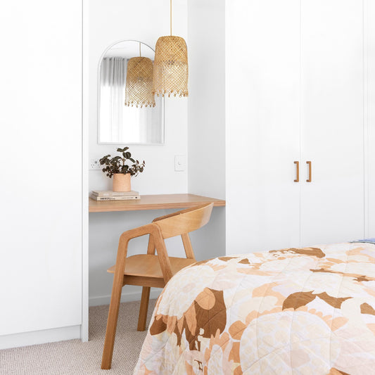 small rattan pendant light hung over a timber built in desk.