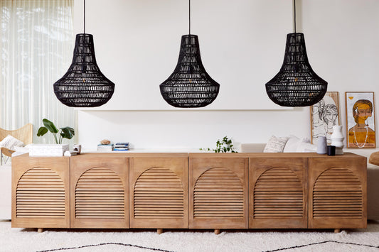 A trio of black Burleigh natural pendant lighting hangs over a gorgeous long timber buffet table.