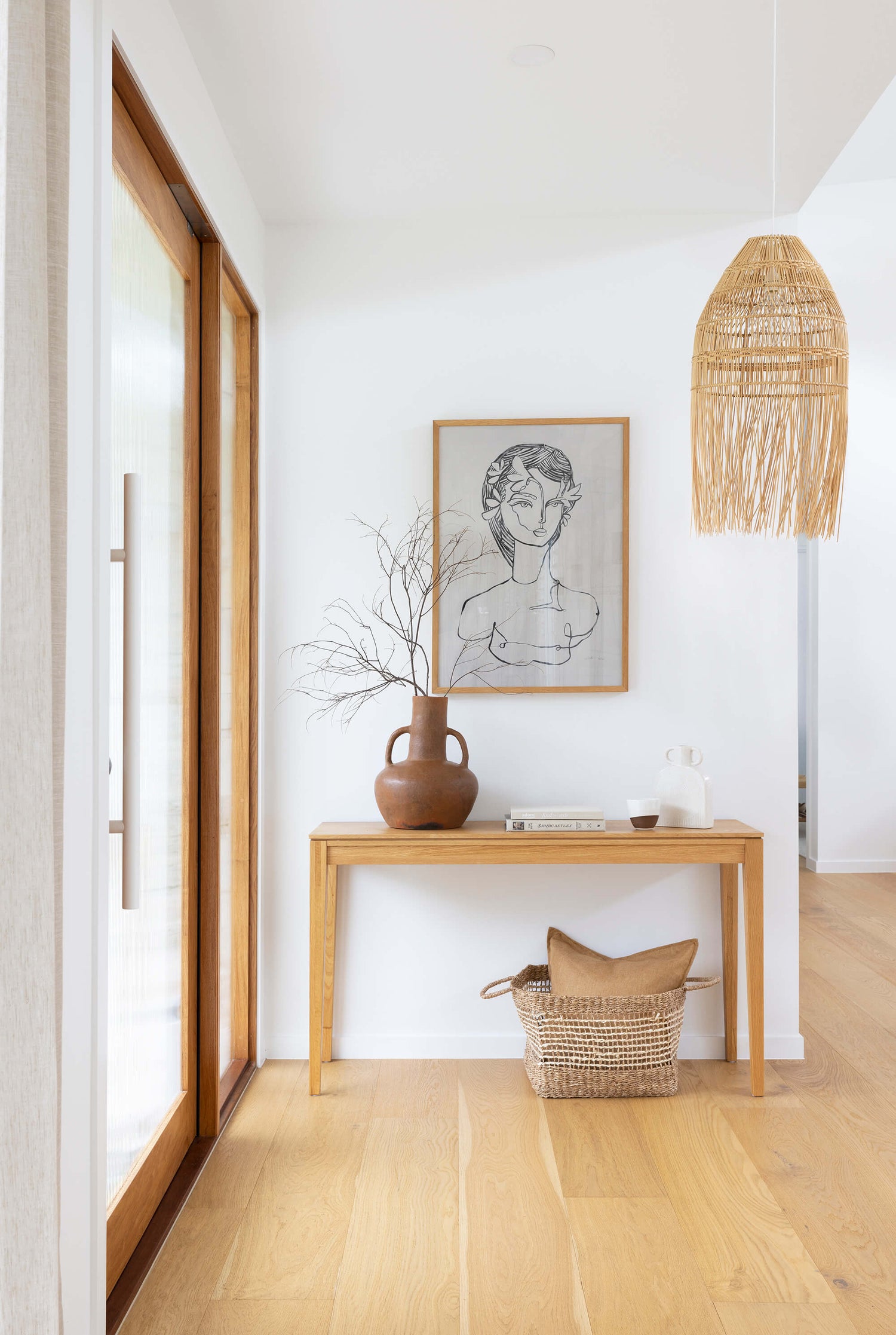A single Bondi handmade pendant light hangs above a hallway table in a modern coastal house.