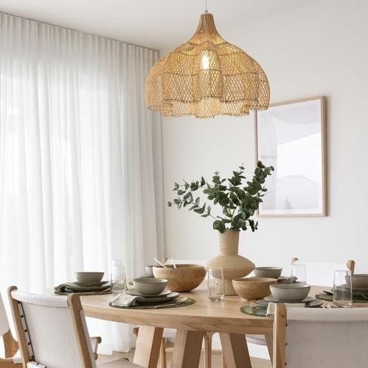 Large Whitehaven dining room pendant light hangs over a green and natural table setting.
