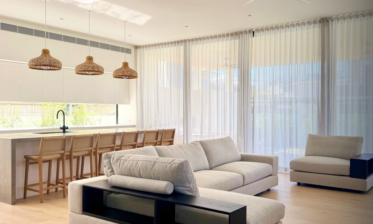 three bamboo lights over a monochrome kitchen and living area