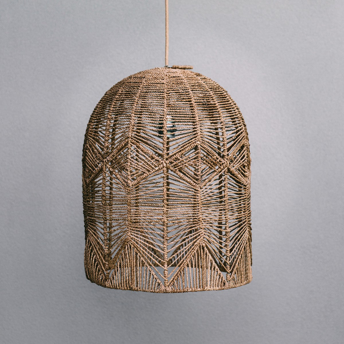 Pendant light seagrass. Product photograph of handmade dome shaped pendant light on a grey background. allows you to see the beautiful pattern in the weave.