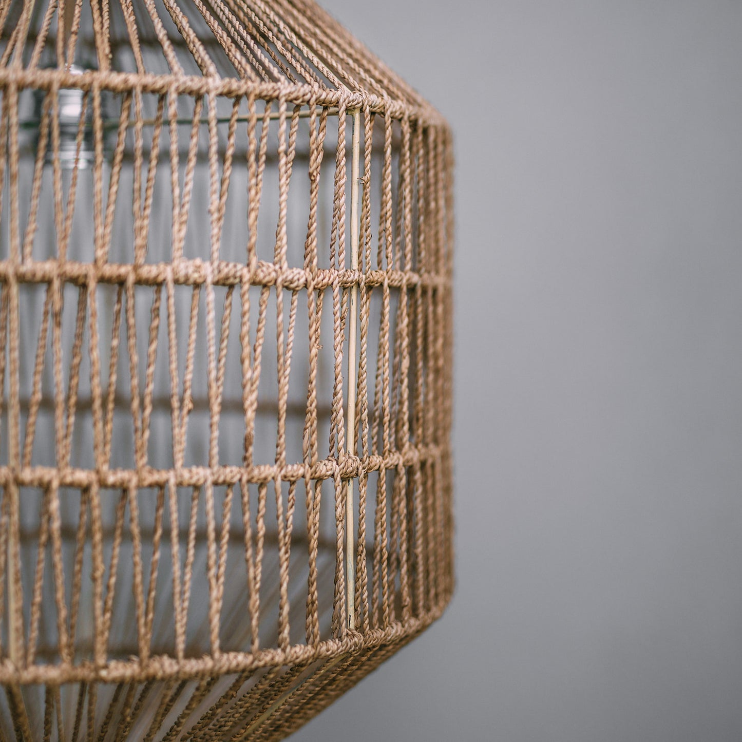Seagrass pendant light shade. close up photograph showing the weave of the seagrass against a grey background.