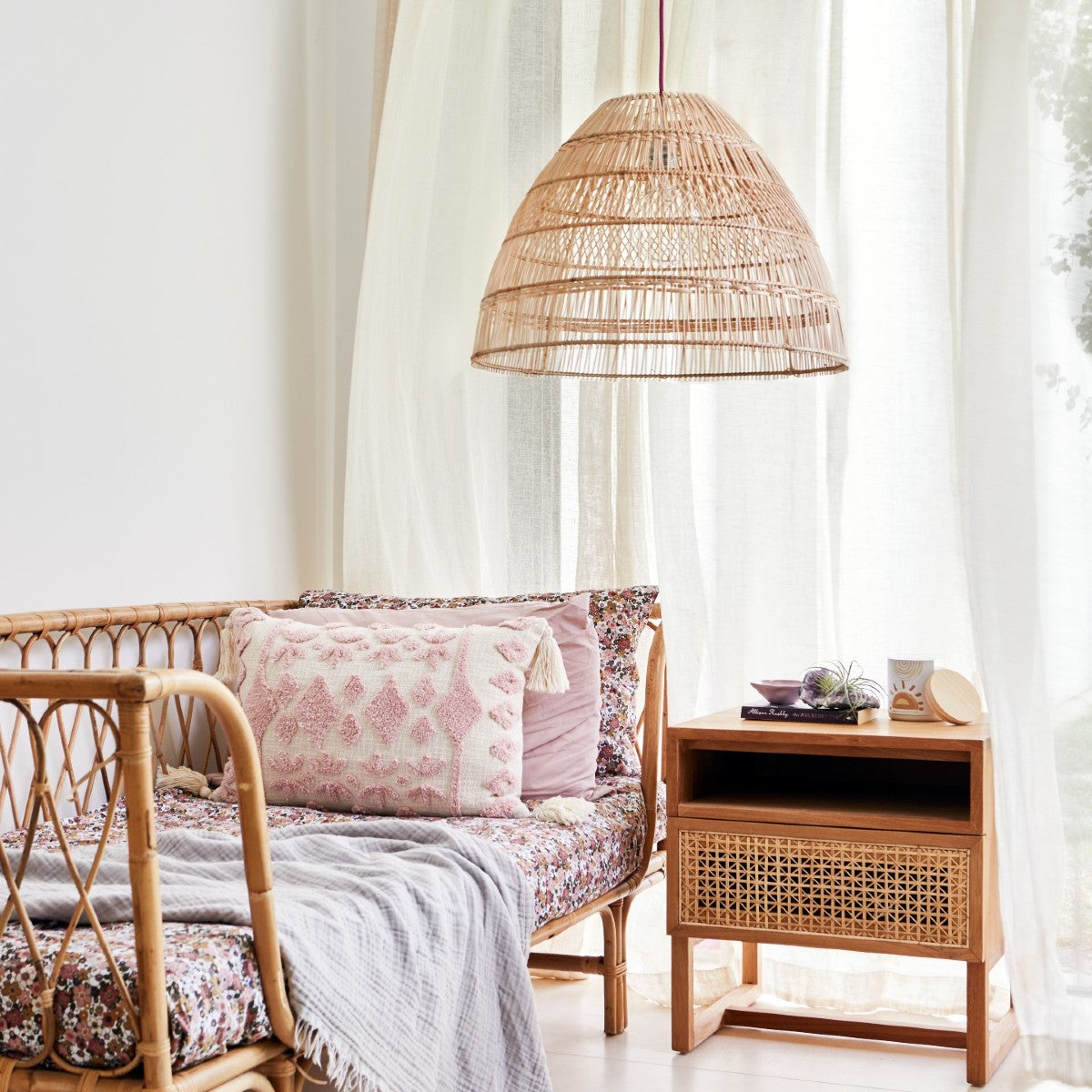 Coastal pendant light.Beautiful-lifestyle-photo-of-natural-rattan-pendant-light-shade-in-a-child's-bedroom-featuring-cane-day-bed-and-soft-pink-floral-bed-linen